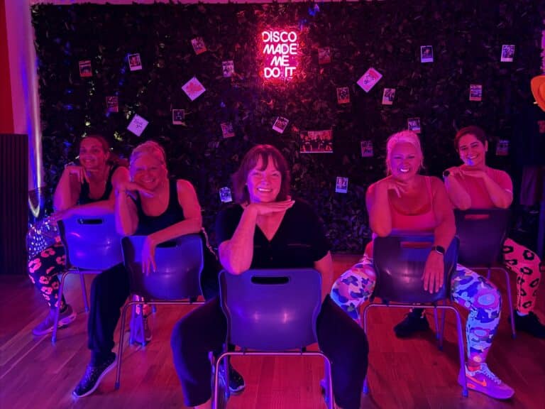 Women posing on chairs at a Sit Down & Slay dance class in Stourbridge